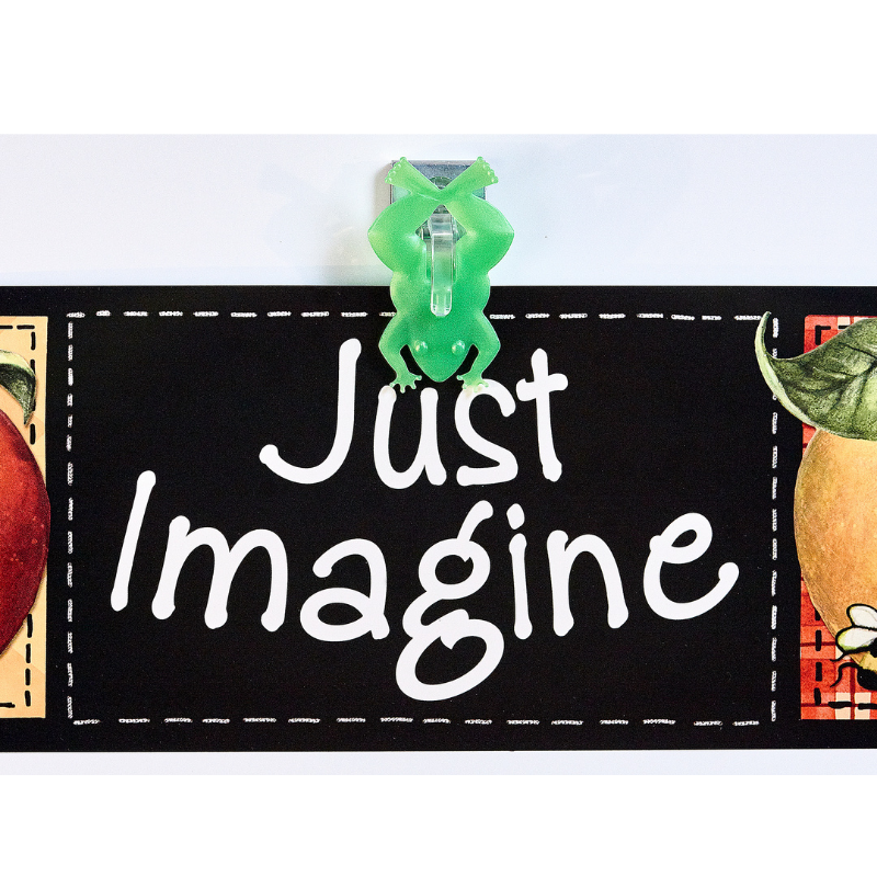 green frog shaped magnetic clip holding sign