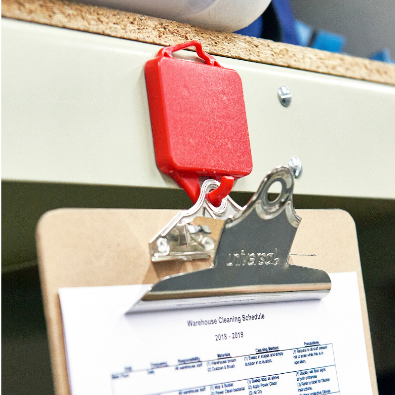 red magnet hook holding clipboard
